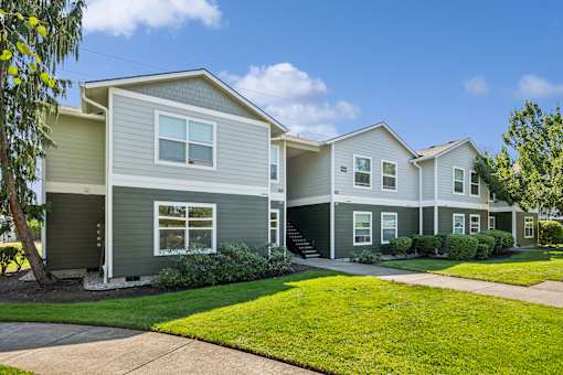 A row of houses with green lawns in front.