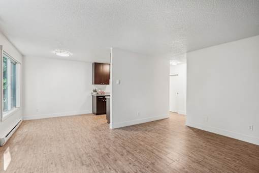 A room with wooden flooring and white walls.