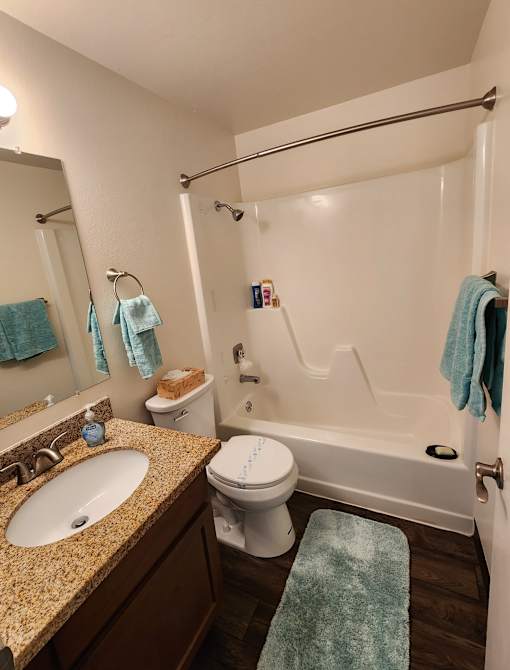 A bathroom with a white toilet, sink, and bathtub.