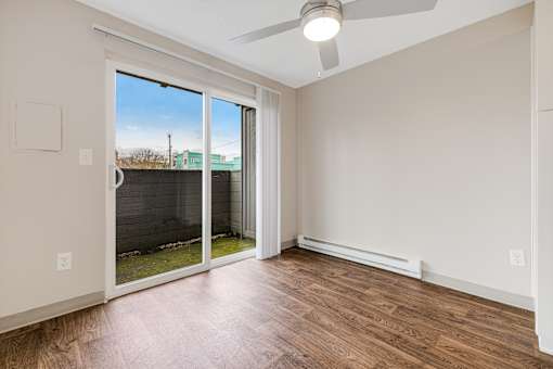 A room with a sliding glass door leading to a backyard.
