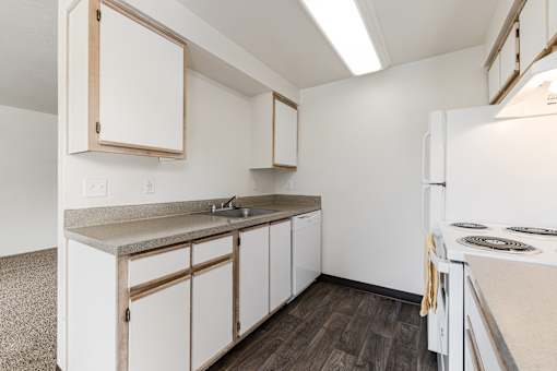 A kitchen with white cabinets and a white refrigerator.