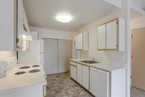 A kitchen with white appliances and cabinets.