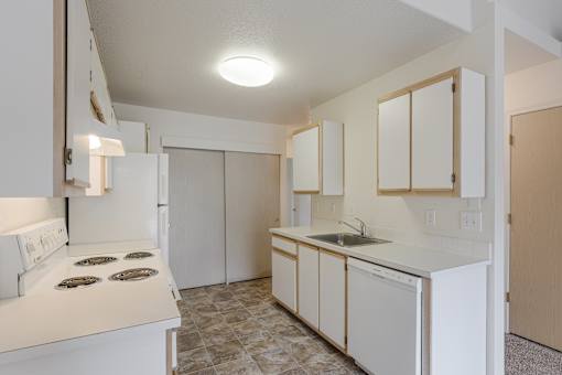 A kitchen with white appliances and cabinets.