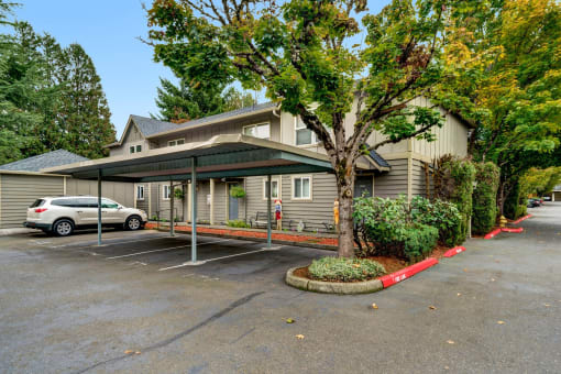the front of a house with a parking lot and a car in front of it
