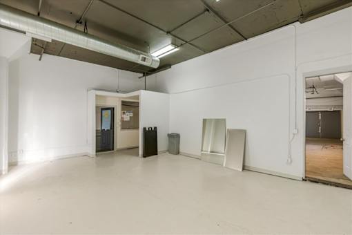 A large empty room with a doorway leading to another room.