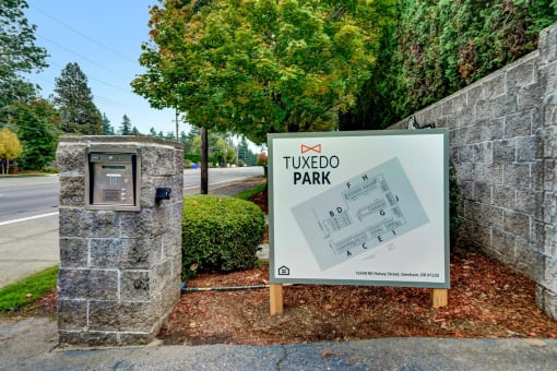 a sign in front of some trees and a road