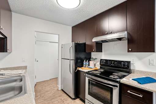 A kitchen with a black stove top oven and a black refrigerator.