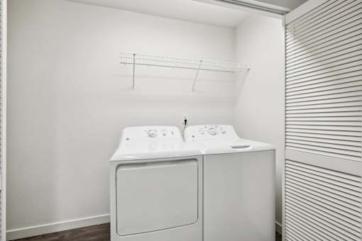 A white washing machine and dryer in a small laundry room.