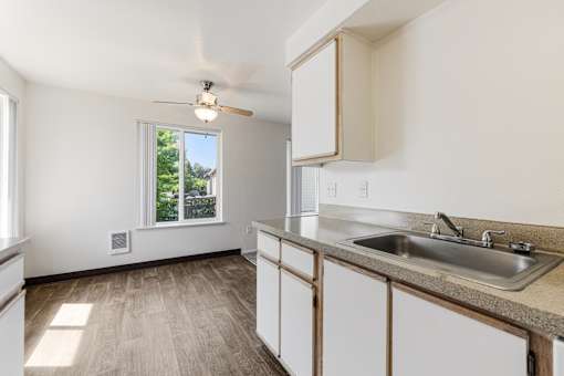 A kitchen with a window and a fan on the ceiling.
