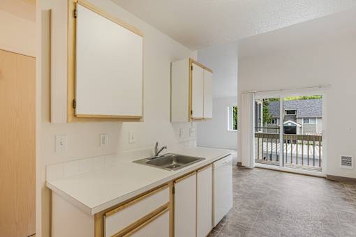 A kitchen with white countertops and wooden cabinets.