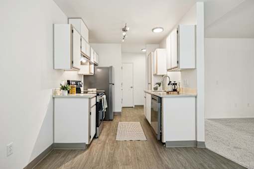 A modern kitchen with white cabinets and stainless steel appliances.