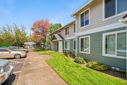 A row of houses with a green lawn in front.