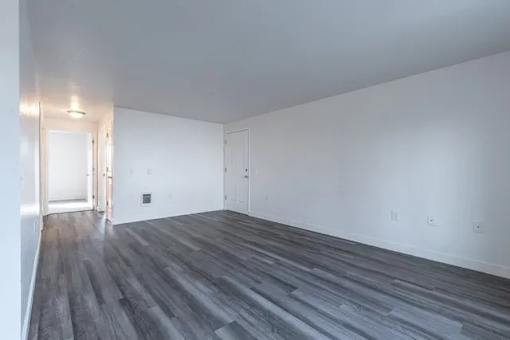 A room with a wooden floor and white walls.