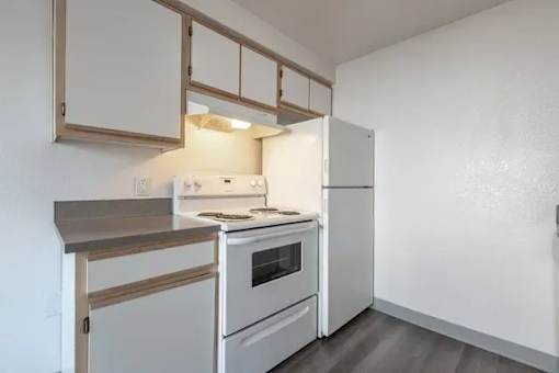 A kitchen with a stove, oven, and refrigerator.