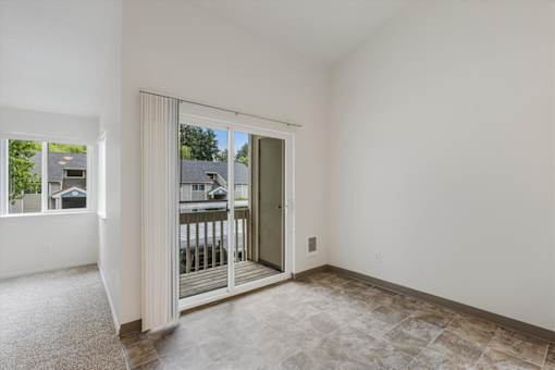 A room with a sliding glass door leading to a balcony.