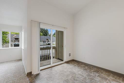 A room with a sliding glass door leading to a balcony.