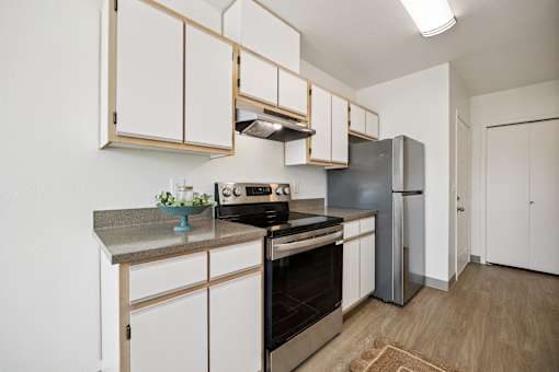 A kitchen with a stove top oven and a refrigerator.