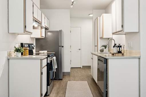 A modern kitchen with white cabinets and appliances.
