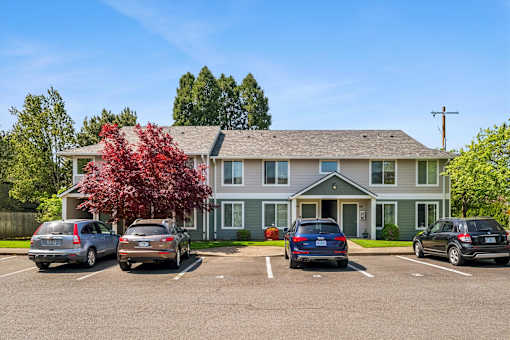 A parking lot with cars and a building in the background.