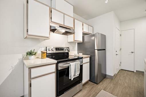 A modern kitchen with a stainless steel refrigerator and oven.