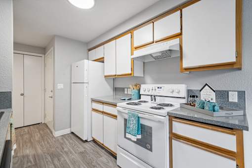 A kitchen with white appliances and wooden accents.