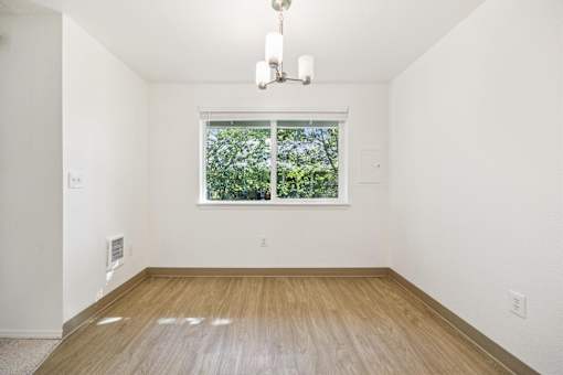 A room with a window and a wooden floor.