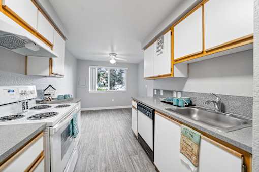 A kitchen with white appliances and wooden cabinets.