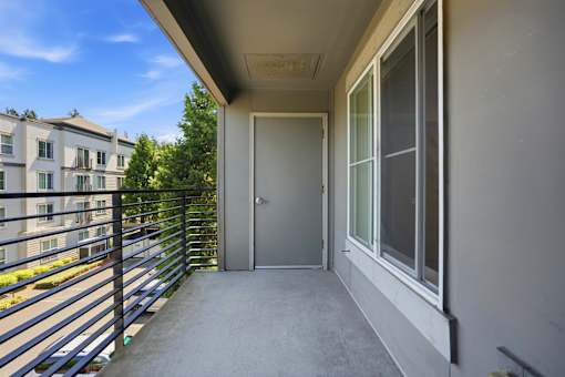 A balcony with a metal railing and a glass door.