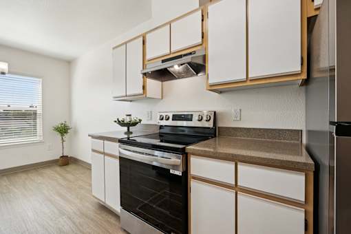 A kitchen with white cabinets and a black stove top oven.