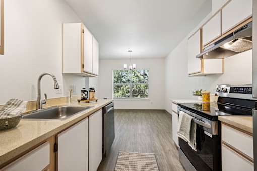 A kitchen with a black oven and wooden cabinets.