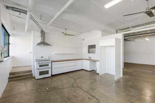 A large open space with a kitchen area and a bar.