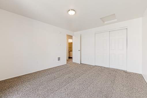 A room with a carpeted floor and white walls.