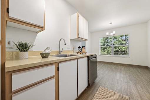A kitchen with white cabinets and a wooden counter.