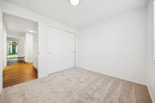 A room with a carpeted floor and a white door.