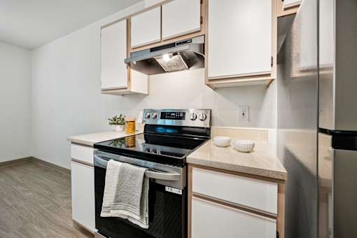 A modern kitchen with a stove, oven, and refrigerator.