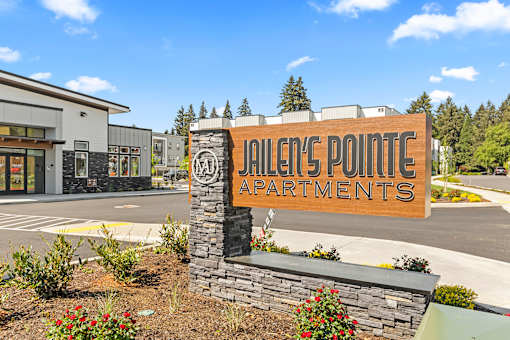 A sign for Jiler's Pointe Apartments is in front of a building.