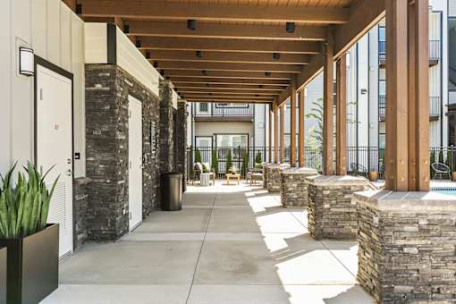 A long hallway with a stone wall on one side and a wooden ceiling.