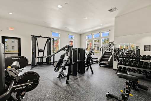 A gym with a variety of equipment including weights and a treadmill.