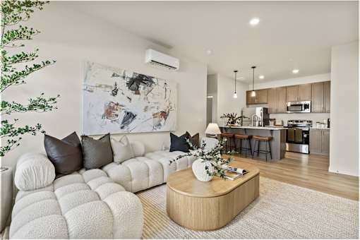 A modern living room with a white sofa and a wooden coffee table.