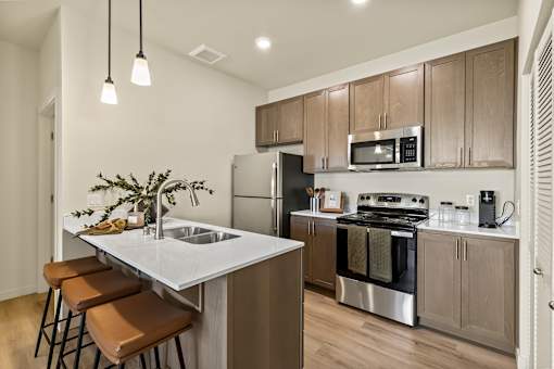 A kitchen with a white countertop and brown bar stools.