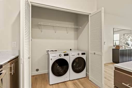 A laundry room with two washing machines and a dryer.
