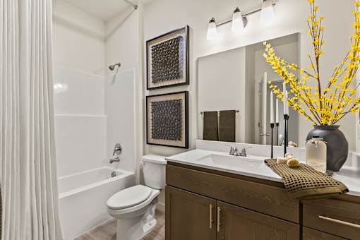 A bathroom with a white tub, sink, and toilet.