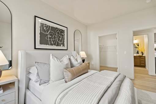 A bedroom with a large bed and a painting on the wall.