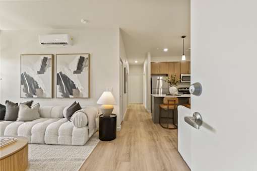 A modern living room with a white sofa and a coffee table.