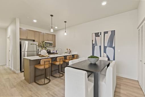 A modern kitchen with a dining table and chairs.