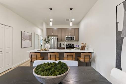 A modern kitchen with a bowl of broccoli on the table.