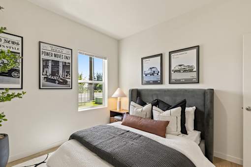 A bedroom with a large bed and three framed pictures on the wall.