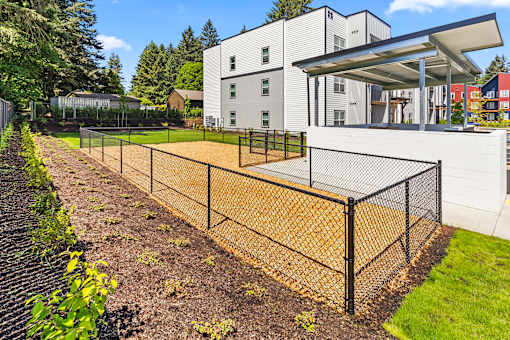 A modern building with a white exterior and a black fence.