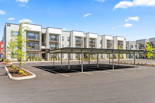 A parking lot in front of a building with a clear blue sky.