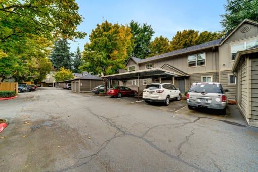 a parking lot with cars parked in front of a house